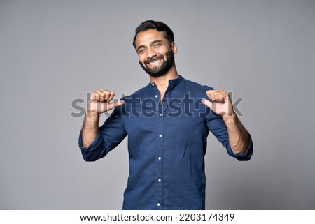 Smiling proud confident indian professional business man standing isolated on gray background pointing at himself bragging as choose me concept. Human resources, self-confidence, ego. Portrait. Royalty-Free Stock Photo #2203174349