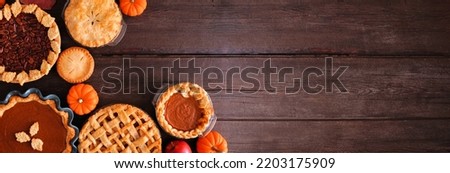 Variety of homemade fall pies. Pumpkin, apple and pecan. Top view corner border on a dark wood banner background with copy space. Royalty-Free Stock Photo #2203175909