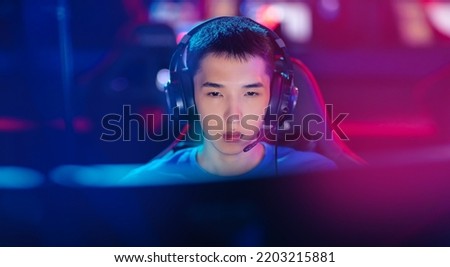 Beauty Young asian man pro gamer streamer playing in online video game, neon color soft focus. Concept banner cyber esport.