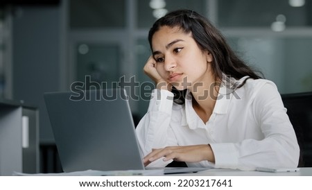 Bored sad lazy young indian woman manager sitting in office unmotivated uninterested in boring laptop work overworked tired sleepy businesswoman feeling tiredness experiencing lassitude exhausted work
