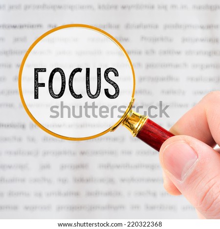Hand Showing focus Word Through Magnifying Glass