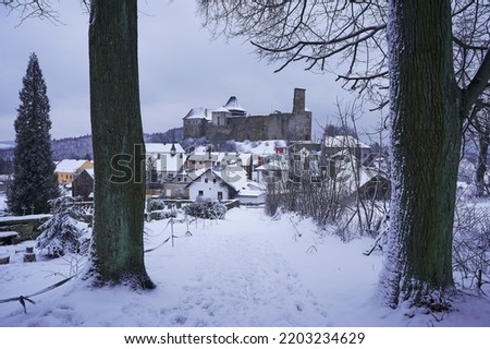 Lipnice nad Sázavou, one of the largest castles in Czech republic, build in gothic style architecture with small pitoresque city under the castle. Picture is taken from cemetery in cold winter sunset.