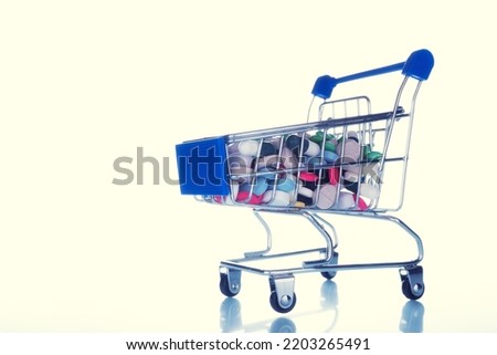 medical pills in a grocery basket on white yellow background. concept of expensive medicines