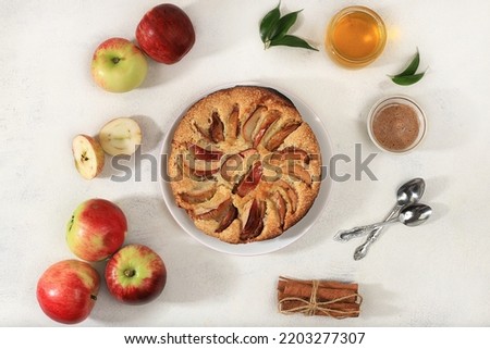Kitchen background with apple pie, honey, apples, spices, cozy warm concept, hello autumn, hygge style, modern bakery advertisement, selective focus, top view,