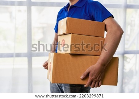 Young man holding a yellow box, delivery service concept.