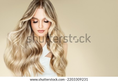 Beautiful girl with hair coloring in ultra blond. Stylish hairstyle curls done in a beauty salon. Fashion, cosmetics and makeup Royalty-Free Stock Photo #2203309231