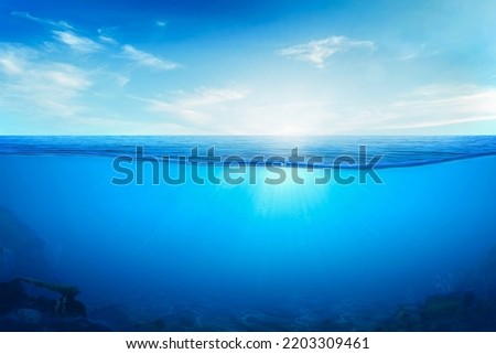BLUE UNDER WATER waves and bubbles. Beautiful white clouds on blue sky over calm sea with sunlight reflection, Tranquil sea harmony of calm water surface. Sunny sky and calm blue ocean. Royalty-Free Stock Photo #2203309461