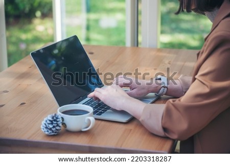 Close up Woman Hands love drinking hot coffee working from home. Business women with black coffee or hot chocolate cafe. Businesswoman hand typing laptop drink black coffee cup in green garden cafe