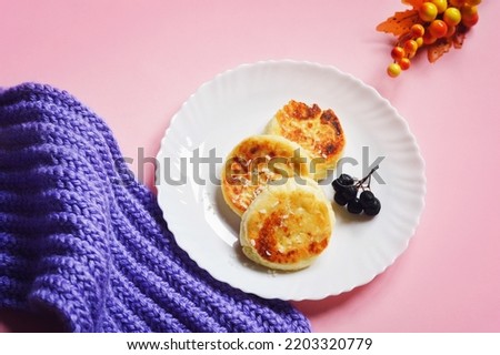 Fluffy cottage cheese pancakes and coffee cup on a pink table. Winter breakfast still life food photography