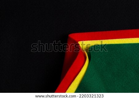 Black History Month color background with copy space for text. Creative geometric curved felt textile background in black, red, yellow, green colors
