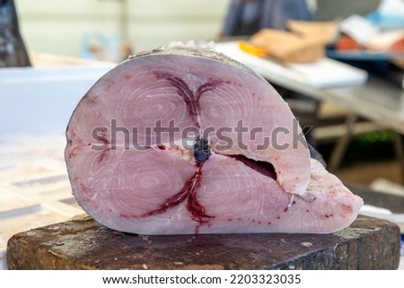 Large piece of raw swordfish on a cutting board at farmer market, Nikiti, Sithonia, Greece. Selective focus. Royalty-Free Stock Photo #2203323035