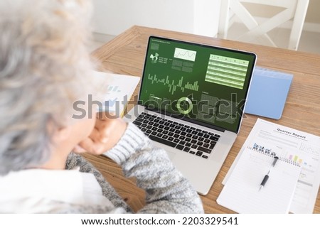 Senior caucasian businesswoman using laptop with data processing. Global business and data processing concept, digital composite image.