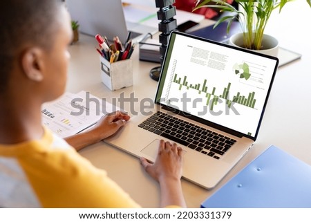 African american businesswoman using laptop with data processing. Global business and data processing concept, digital composite image.