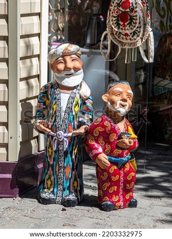 Ceramic figurines depicting two old men in traditional Uzbek national robes and hats Royalty-Free Stock Photo #2203332975
