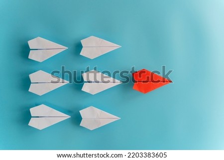 Successful leadership concept red leader paper plane And followed by a white plane on a blue background, strategic planning has been developed.