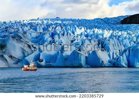 Gray Glacier is part of the South Patagonian Ice Field. The Gray Glacier is the third largest in the world. Boat with tourists floats among icebergs.  Royalty-Free Stock Photo #2203385729