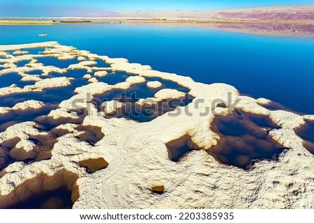 Magic of the Dead Sea. Evaporated salt patterns on the surface of the blue water. The photo was taken from a drone. Cold sunny winter day. Israel. 