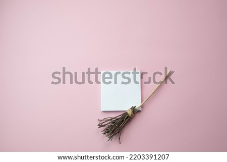 witch's broom on a light pink background with a place for text, the concept of a creative happy Halloween
