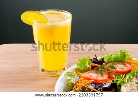 light meals for a good diet and healthy life with a plate of chicken and brown rice with salad and orange juice