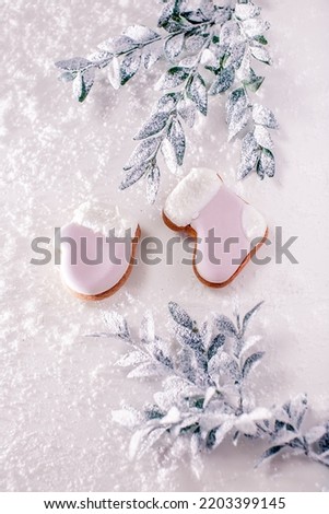 fragrant gingerbread in the form of a boot, mittens, hats, Christmas trees, snowflakes under white fluffy snow near the Christmas tree on a white background