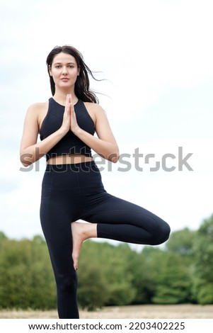 Portrait of young caucasian woman doing yoga in a forest in London. Healthy, natural concept.