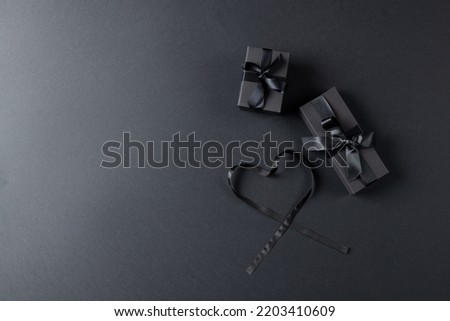Composition of presents with ribbons and ribbon heart on gray background. Retail, shopping and black friday concept.