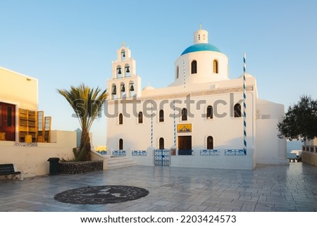 The traditional white wash and blue dome Greek Orthodox Church of Panagia Akathistos Hymn and courtyard in the traditional old town of Oia on the Greek Island of Santorini, Greece. Royalty-Free Stock Photo #2203424573