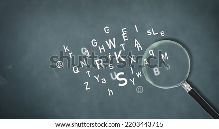 Magnifying glass and latin letters on a gray background