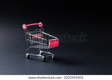 Composition of shopping cart and copy space on gray background. Retail, shopping and black friday concept.