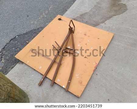 A construction sign that is lying face down on a sidewalk.