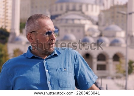 Adult man walking in the city on a sunny summer day