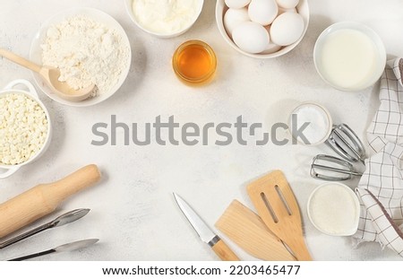 Kitchen background for baking and cooking cake, bread, confectionery and ingredients for cooking, milk, honey, flour, salt, sugar, eggs and cream on a concrete background with space for text,