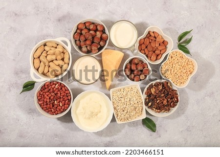 Vegan non-dairy products on a concrete table, plant-based alternative dairy products - milk, cream, yogurt, cheese, nuts, rice, oatmeal, lentils, healthy natural food concept, top view, 