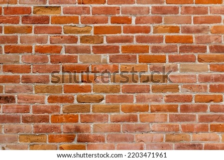 Full frame abstract texture background of a 19th century red brick wall with charming old clay bricks showing natural weathering from age