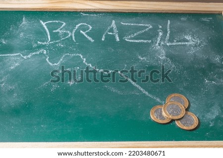 Green chalkboard With the word "Brazil" written with white chalk and a graphics with a falling arrow,copy space.