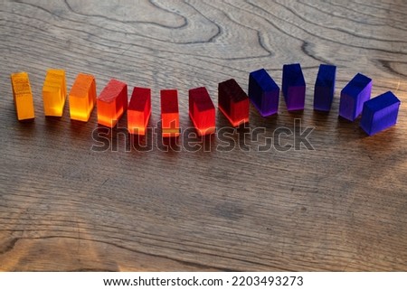 Flexible or curved concept. Colorful wooden blocks aligned in a curve on an old vintage wooden table. Yellow orange to purple colors. Copyspace for cover, header usage.