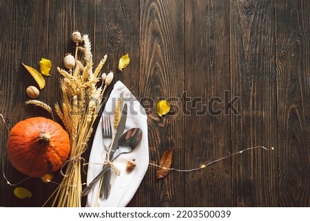 Happy Thanksgiving. Autumn composition with leaves, ripe pumpkin and Thanksgiving turkey on a dark wooden table. Top view.