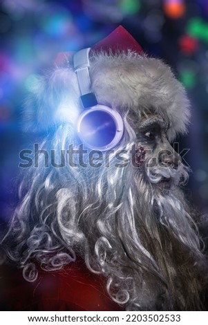 Christmas party for zombies. Sideview portrait of a scary and cool DJ zombie Santa Claus in headphones. Black background with colorful lights. Halloween.