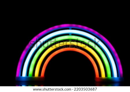 Image of vibrant neon glow sticks forming rainbow over black background with copy space. Lgbt, equality, love, light and colour concept.