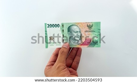 male hand holding new rupiah banknote in 2022. new 20,000 or twenty thousand rupiah denomination isolated on white background Royalty-Free Stock Photo #2203504593