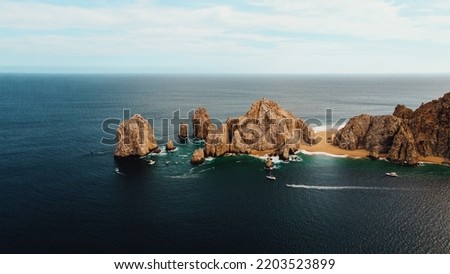 Drone Aerial panoramic view of the Arch (El Arco) of Cabo San Lucas marina, Mexico, and the rock formations at Lands End and the southernmost tip of the Baja California peninsula. Royalty-Free Stock Photo #2203523899