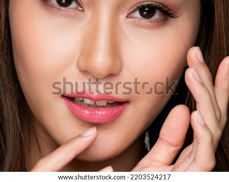 Closeup portrait of ardent young girl with healthy clear skin and soft makeup looking at camera and posing beauty gesture. Cosmetology and beauty concept.