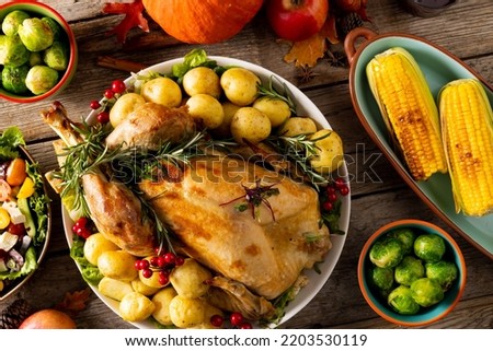 Overhead view of thanksgiving table with roast turkey, vegetables and autumn decoration on wood. Thanksgiving, autumn, fall, american tradition and celebration concept.