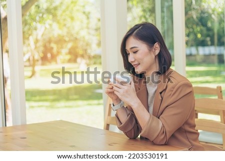 Asian Woman drink black coffee hand holding cup at green garden cafe. Young woman smile face love drink coffee. Beauty woman drinking black coffee in green garden cafe holding freshness cup