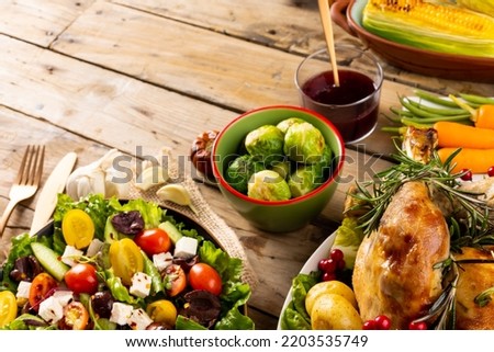 Overhead view of thanksgiving table roast turkey, vegetables and copy space on wood. Thanksgiving, autumn, fall, american tradition and celebration concept.