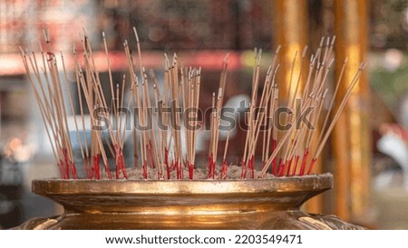 Lots of incense sticks on the incense burner. in a temple.