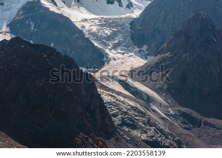 Atmospheric landscape with large snow mountain range in sunny day. Glacier and icefall in bright sun among sharp rocks. Awesome mountain view to high snowy mountains. Sunlit beautiful icefall close-up Royalty-Free Stock Photo #2203558139