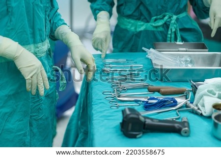 Assistant Orthopedic doctor preparing instruments for operation bone on the table. keeping the surgical equipment sterile.