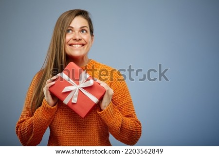 Portrait happy woman with present gift box isolated on blue background.