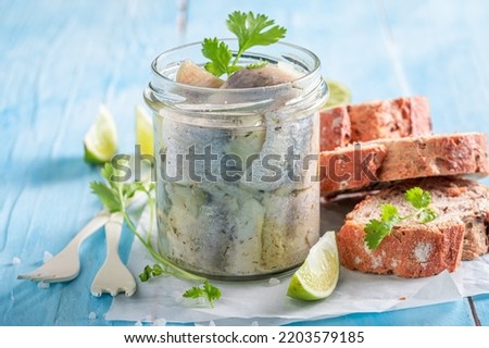 Delicious and fresh pickled fish served with bread and coriander. Herring marinated with oil and salt. Royalty-Free Stock Photo #2203579185